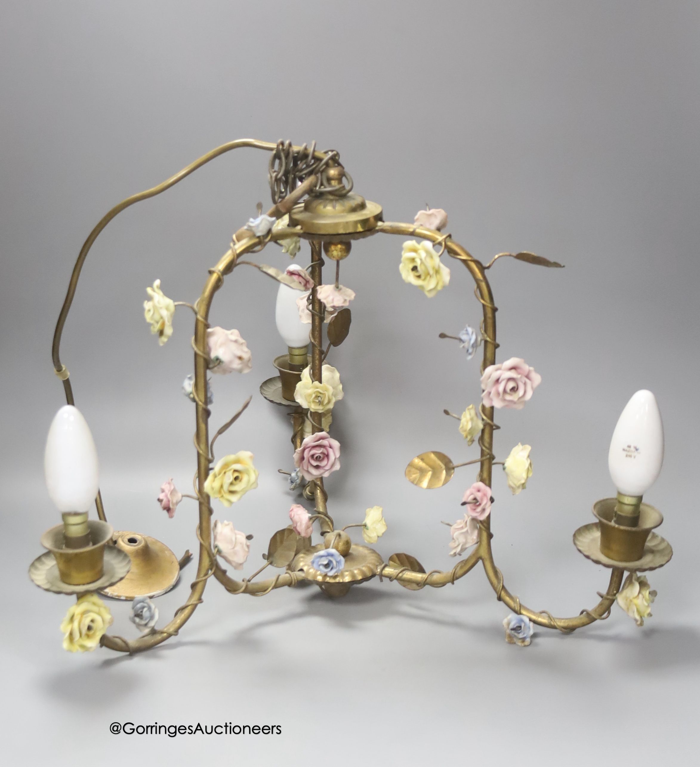 A floral encrusted brass three light ceiling fitting, width 40cm